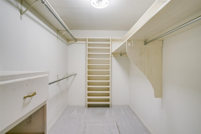 walk in closet featuring light colored carpet