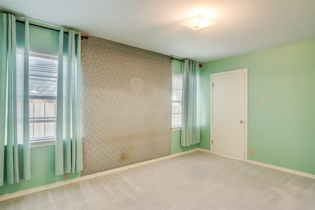 unfurnished room featuring light colored carpet and a healthy amount of sunlight