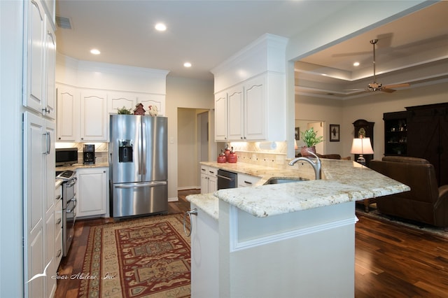 kitchen featuring sink, stainless steel appliances, white cabinetry, and kitchen peninsula