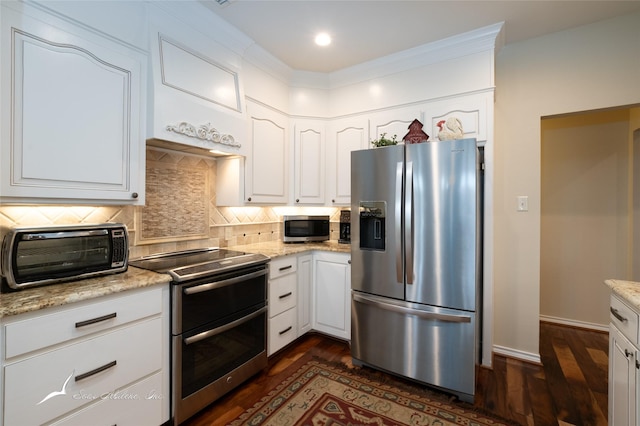 kitchen featuring white cabinets, light stone counters, appliances with stainless steel finishes, and tasteful backsplash