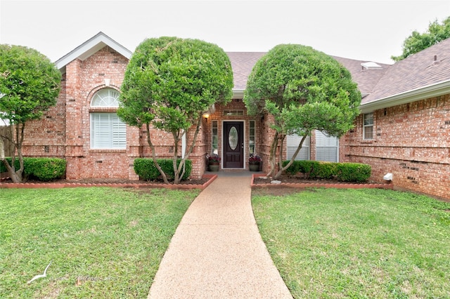 view of exterior entry featuring a yard