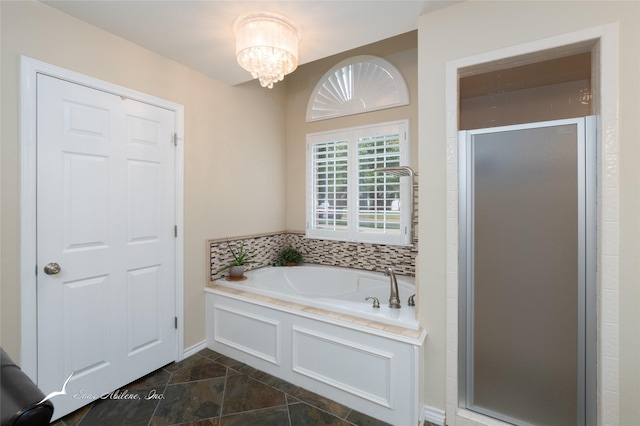 bathroom featuring an inviting chandelier and shower with separate bathtub