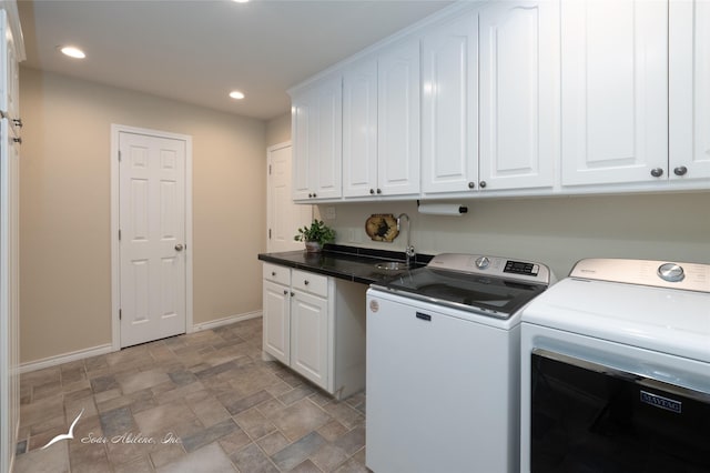 washroom with washer and clothes dryer and cabinets