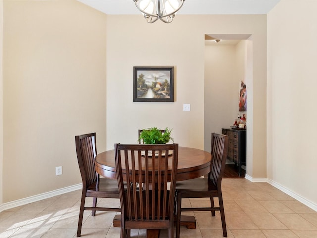 dining space with a notable chandelier and light tile patterned flooring