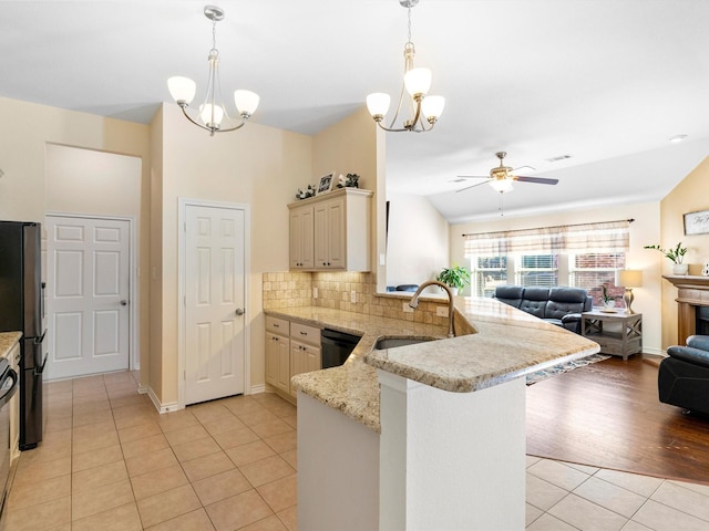 kitchen with kitchen peninsula, sink, stainless steel fridge, and light tile patterned floors