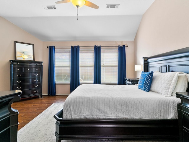 bedroom featuring ceiling fan, dark wood-type flooring, multiple windows, and lofted ceiling