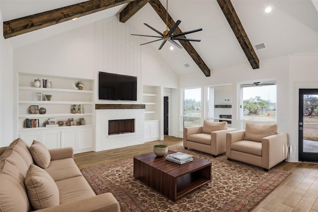 living room featuring built in features, hardwood / wood-style flooring, high vaulted ceiling, and ceiling fan