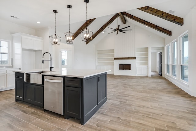 kitchen with dishwasher, decorative light fixtures, built in features, white cabinetry, and a kitchen island with sink