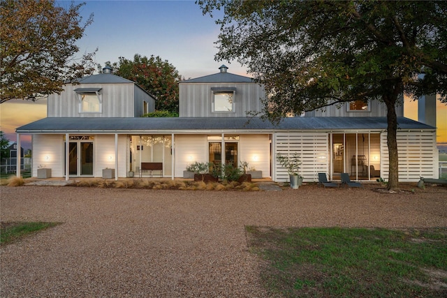 back house at dusk with covered porch