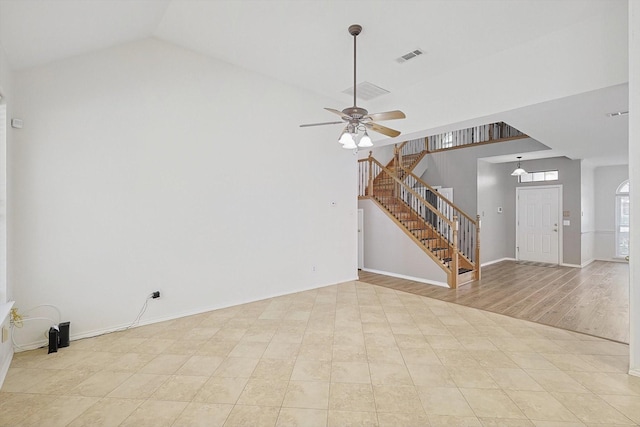 unfurnished living room featuring a towering ceiling, ceiling fan, and light hardwood / wood-style flooring