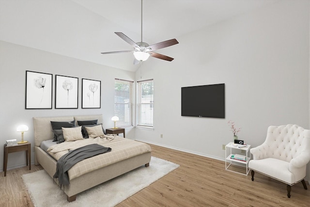 bedroom with ceiling fan, hardwood / wood-style floors, and lofted ceiling