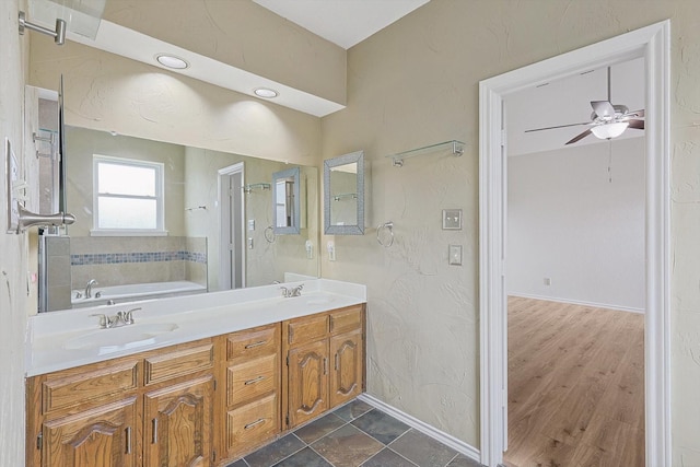 bathroom featuring a bathtub, ceiling fan, and vanity