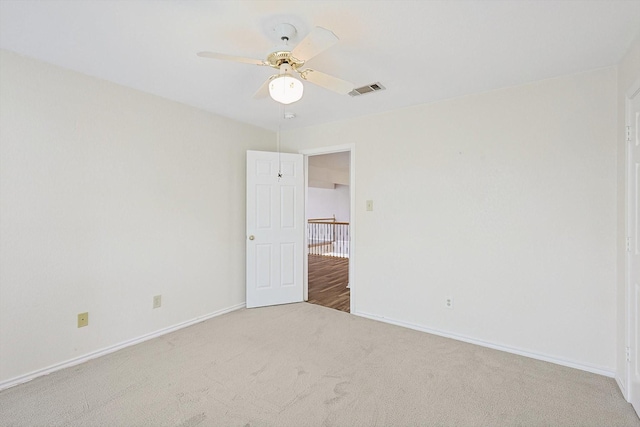 empty room featuring light colored carpet and ceiling fan