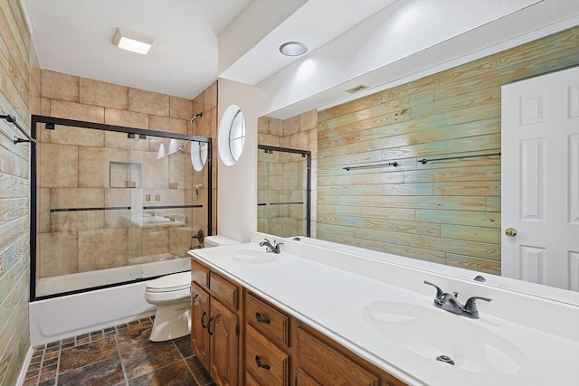 full bathroom with enclosed tub / shower combo, vanity, and toilet