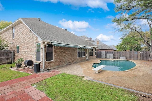 view of pool featuring a diving board, a patio area, and a yard