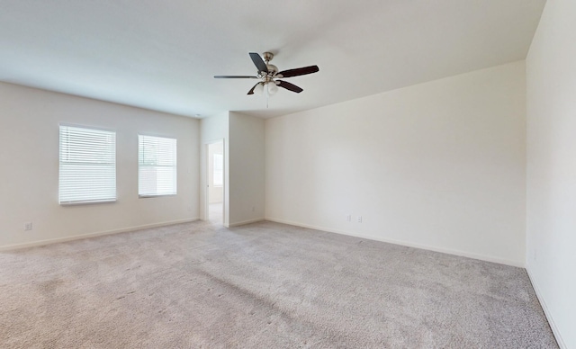 carpeted spare room with ceiling fan