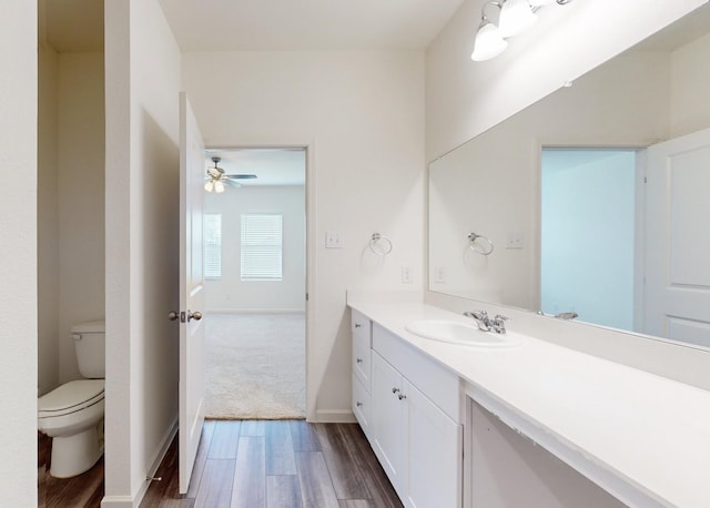 bathroom with wood-type flooring, toilet, and vanity