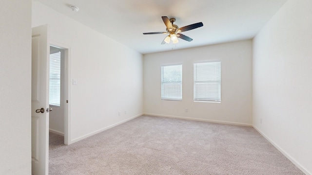 carpeted spare room featuring ceiling fan