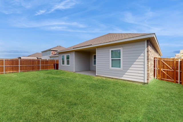 rear view of house featuring a patio area and a yard