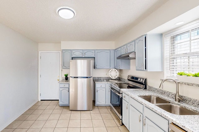 kitchen with sink, light tile patterned floors, a textured ceiling, and appliances with stainless steel finishes