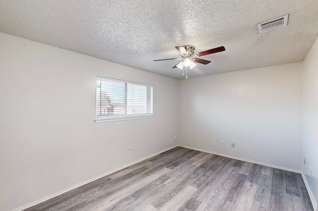 empty room featuring ceiling fan, wood-type flooring, and a textured ceiling