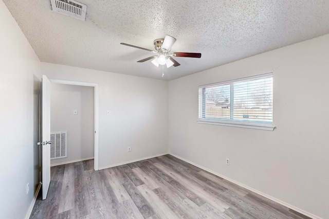 spare room featuring ceiling fan, a textured ceiling, and light hardwood / wood-style floors