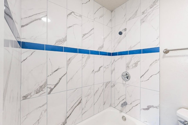 bathroom with tiled shower / bath and toilet