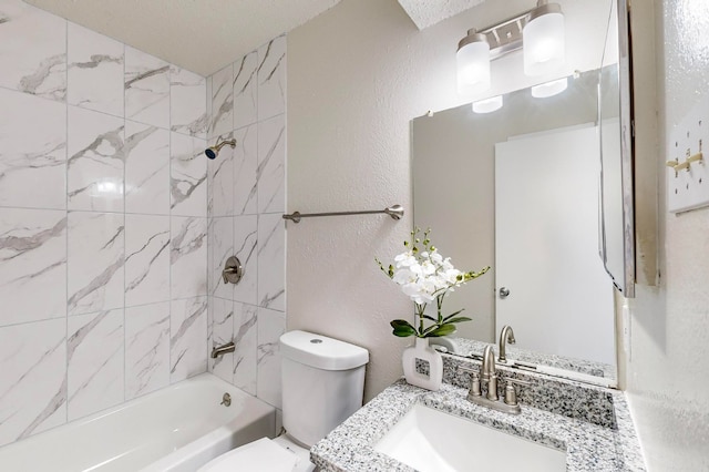 full bathroom featuring vanity, a textured ceiling, toilet, and tiled shower / bath