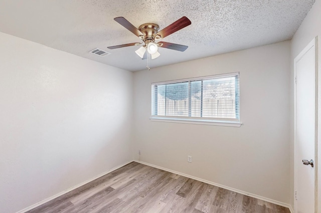 empty room with ceiling fan, light hardwood / wood-style floors, and a textured ceiling