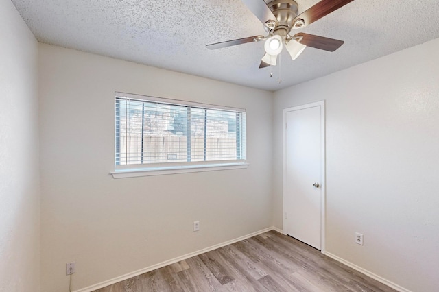 unfurnished room with ceiling fan, a textured ceiling, and light hardwood / wood-style flooring