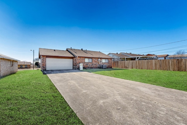 ranch-style home featuring a garage, a front yard, and central air condition unit