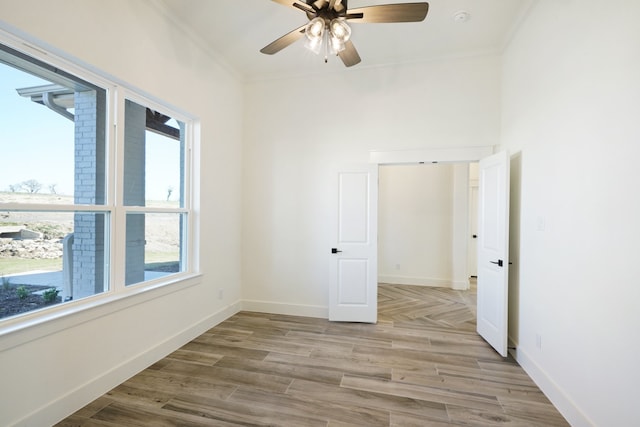 spare room featuring light hardwood / wood-style floors, ceiling fan, and ornamental molding