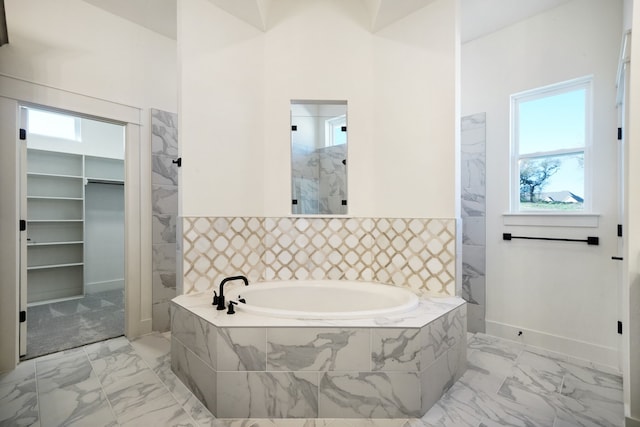 bathroom with a relaxing tiled tub