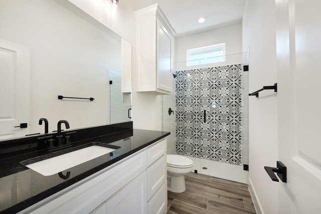 bathroom featuring vanity, toilet, and a shower