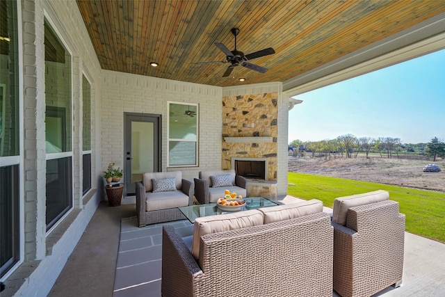 view of patio with an outdoor living space with a fireplace, a rural view, and ceiling fan