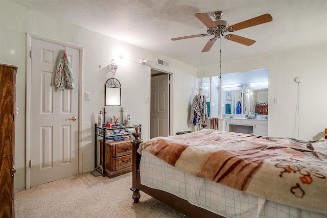 bedroom featuring ceiling fan, light colored carpet, and a textured ceiling