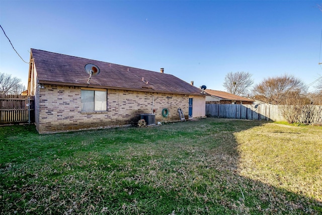 rear view of house with a yard and cooling unit