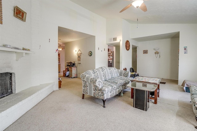 living room featuring a fireplace, light colored carpet, lofted ceiling, and ceiling fan