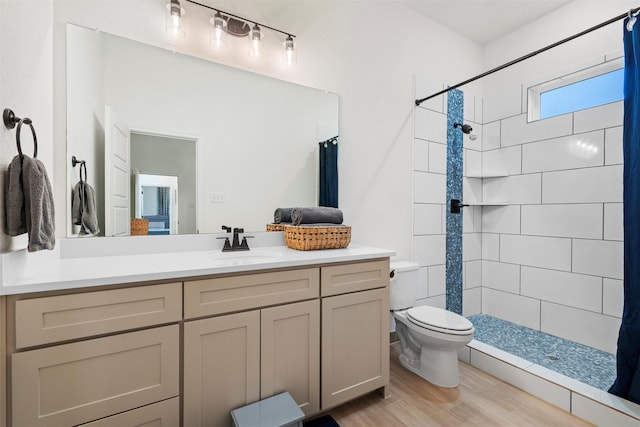 bathroom with hardwood / wood-style flooring, toilet, vanity, and a shower with shower curtain