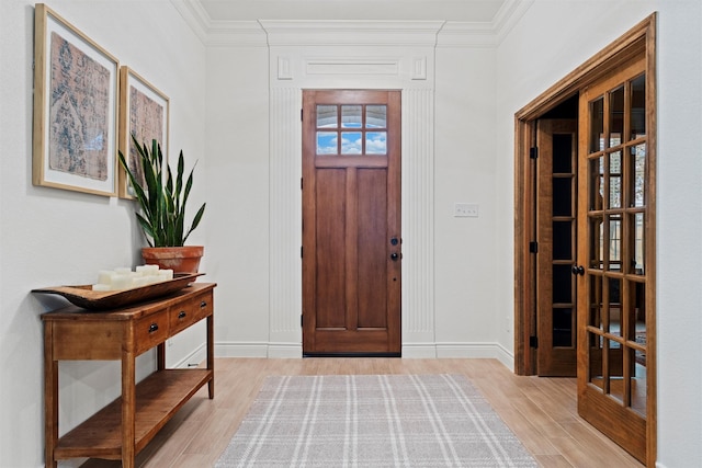 entryway with crown molding and light hardwood / wood-style floors