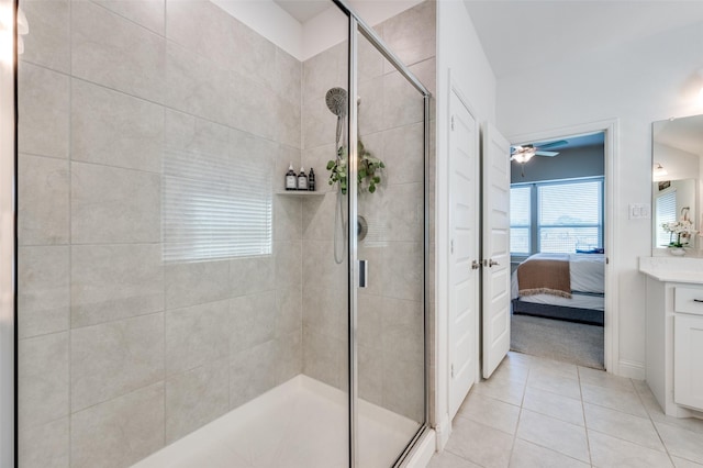 bathroom with vanity, a shower with shower door, ceiling fan, and tile patterned flooring