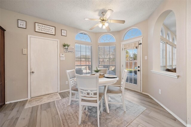 dining space with a textured ceiling and light wood-type flooring