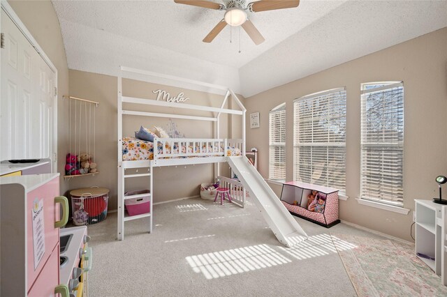 carpeted bedroom with ceiling fan, a textured ceiling, and vaulted ceiling