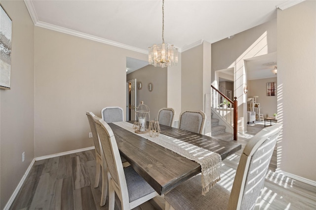 dining space with light hardwood / wood-style flooring, crown molding, and a chandelier