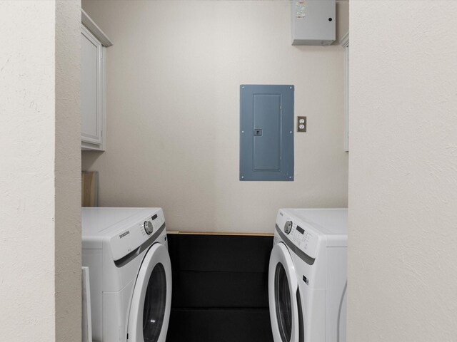 washroom with washing machine and clothes dryer, electric panel, and cabinets