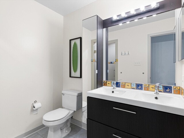 bathroom featuring vanity, toilet, and tile patterned flooring