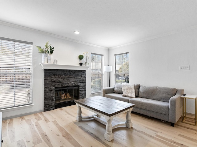 living room with a fireplace, crown molding, and light wood-type flooring