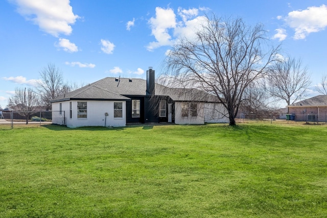 rear view of property featuring a yard