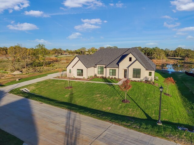 view of front of home featuring a front yard and a water view