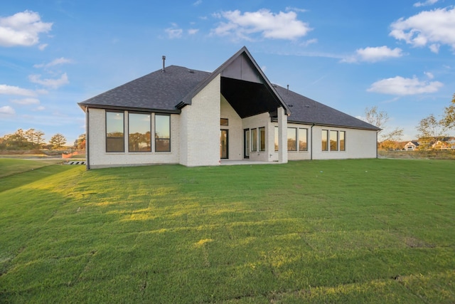 back of property with a patio area and a lawn